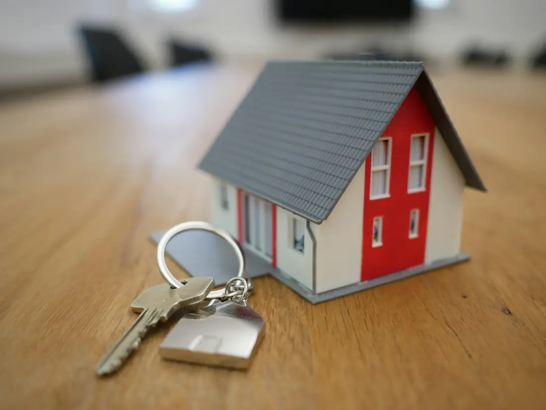 Llaves de una vivienda junto a una casa en miniatura